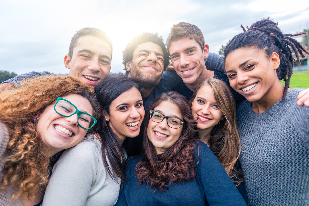 Multiracial people together in a selfie making funny faces - Group of friends with mixed races having fun together at park - Friendship and lifestyle concepts